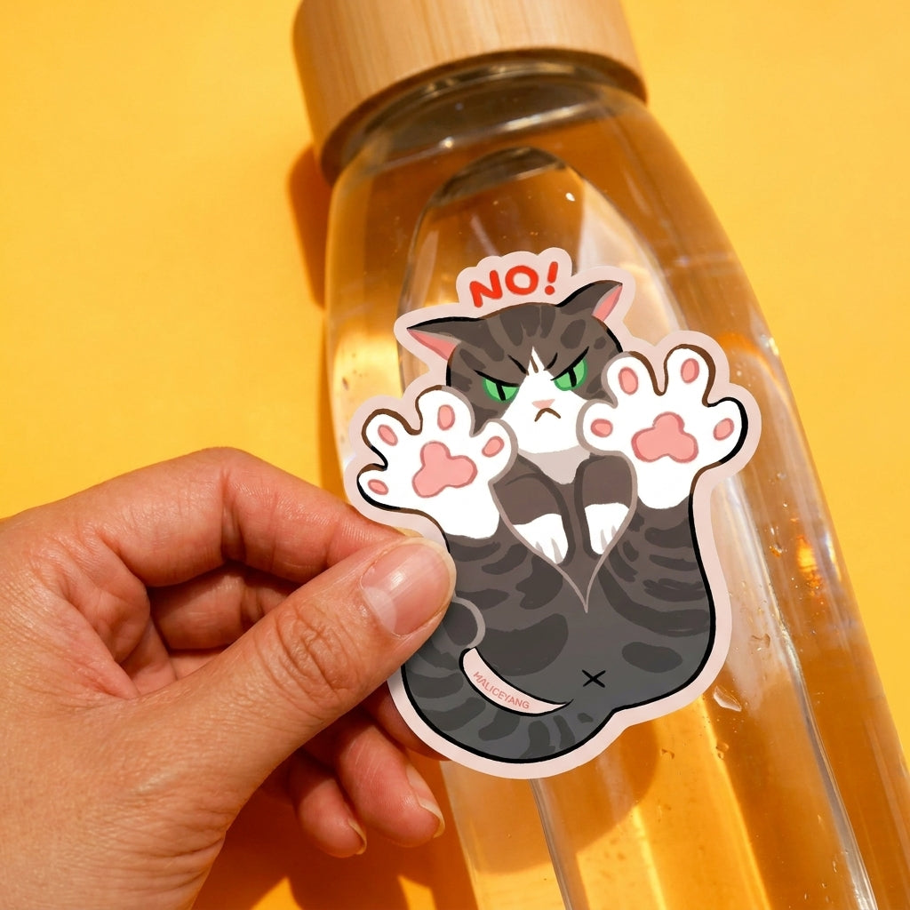 No! Cat Toe Beans waterproof vinyl sticker being applied to a clear water bottle by a feminine hand against the same bright yellow background.