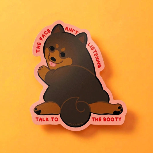 Primary Talk to the Booty Shiba die-cut waterproof vinyl sticker featuring a seated brown Shiba with a coral border and the words “THE FACE AIN’T LISTENING” and “TALK TO THE BOOTY” on a warm yellow background.